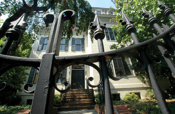 The Georgetown house is entered through a decorative wrought-iron front gate. 