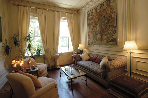 An ancient mosaic wall mural and chinese horse accent the comfortably furnished living room. 