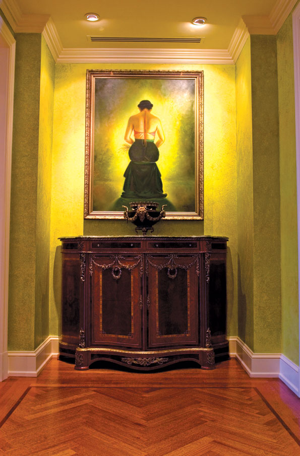 The entry hall of William and Janet Cohen's Chevy Chase penthouse features an oil painting of a young Vietnamese woman alongside an ornate French Empire style cabinet. 