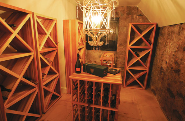 The wine cellar has a built-in refrigerator; the decorative chandelier creates a focal point in the center of the room. 