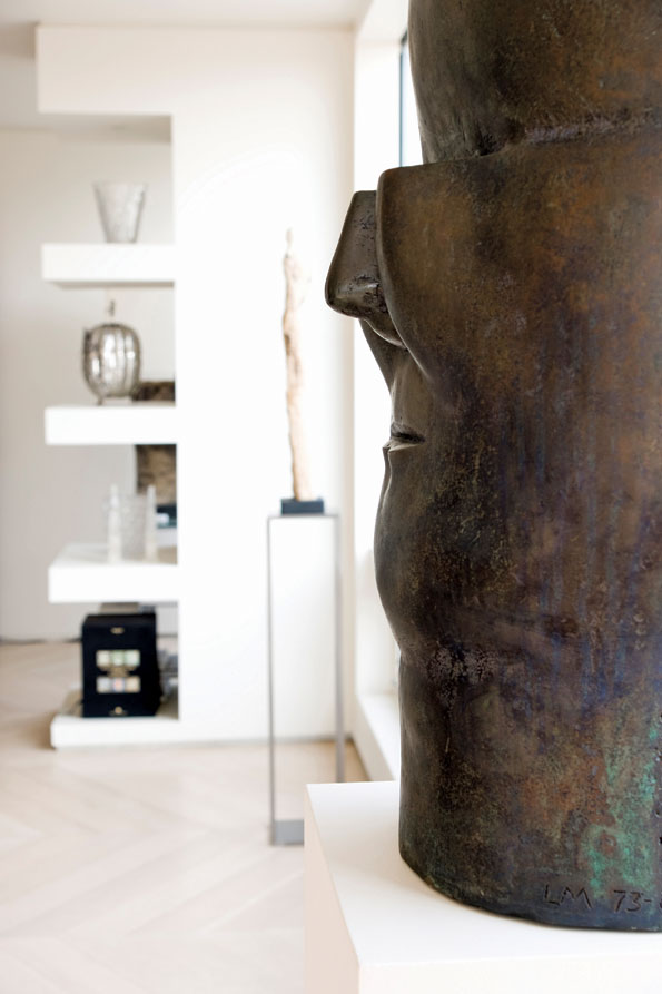 A large scale, massive bronze sculpture by Chilean artist Luis Madiola (foreground) is juxtaposed against the floating display shelves in the background. 