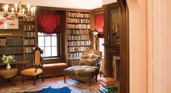 Off the living room, the walnut-paneled library incorporates built-in window seats and shelving holding books in Russian and English.  The oriental rug and tapestry-upholstered bergere are typical of the furnishings throughout the house. 