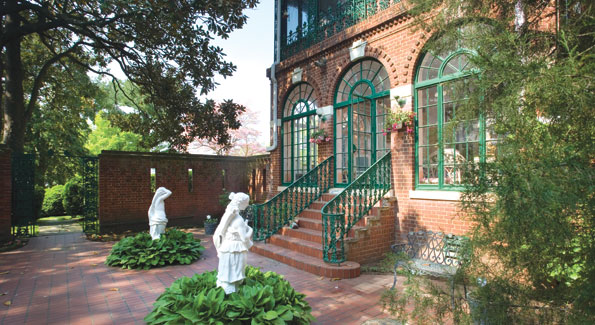 Wrought ironwork accents the brick facade fronting the side courtyard off the enclosed living room porch. 