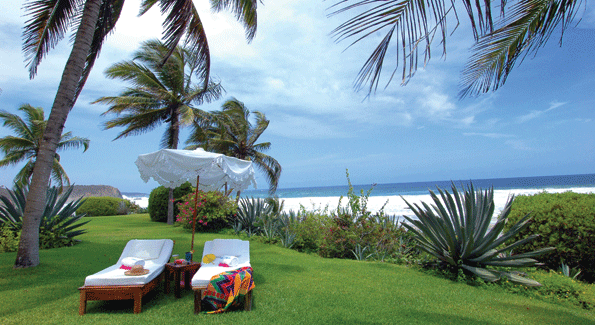 Chaise lounges on the lawn of an oceanfront villa