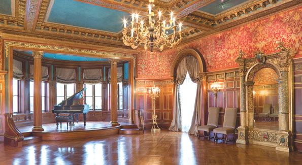 The ballroom was most likely designed around the antique 19th Century red silk tapestry based on 16th Century patterns. The ornate circular latticed doorway and the ornamented vaulted ceiling of gold leaf and turquoise carvings are as spectacular as the original parquet flooring. Pearl grey silk peau-de-soie curtains and matching ballroom chairs compliment the tapestry. 