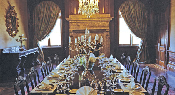 The dining room features a magnificent bronze and silver Balthazar clock, three silver and crystal chandeliers, and two 18th century silver-arm candelabras atop an original Hepplewhite dining table. 