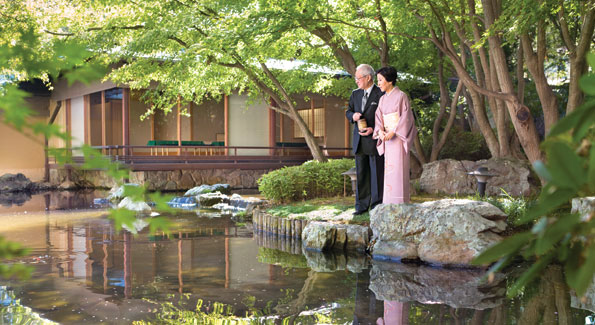 Ambassador Kato and Mrs. Kato take a moment to feed the carp in the residency's Koi pond. The tea house in the background was first built in Japan and then reassembled at the residence. 