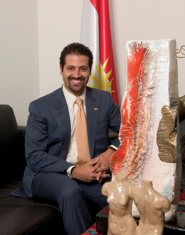 Qubad Talabany relaxes in his office next to a collection of works by Kurdish artists. 