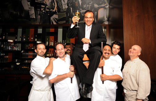 Raise a glass (and a chair)Raise a glass (and a chair) to Ashok Bajaj (seated), who "feeds the in-crowd" at seven of Washington's top restaurants. Left to right: executive chefs Adam Longworth (701 Restaurant), Tony Conte (The Oval Room), Nilesh Singhvi (The Bombay Club), Vikram Sunderam (Rasika) Nicholas Stefanelli (Bibiana), and Alex McWilliams (Ardeo and Bardeo) (Photo by James R. Brantley).