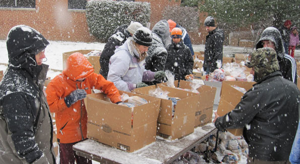 Volunteers brave a snowstorm to distribute produce, meat and other essentials to over 3,000 Alexandrians. (Photo by Jane Hess Collins)