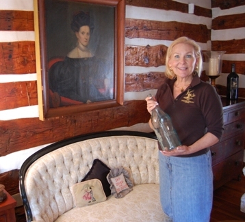 Winery founder Jane Kincheloe holds a vintage bottle from the 19th century days of the old Paradise Springs. Photo by John Arundel 