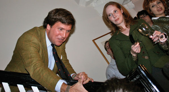 Tucker Carlson greets guest at his launch party as Juleanna Glover looks on.