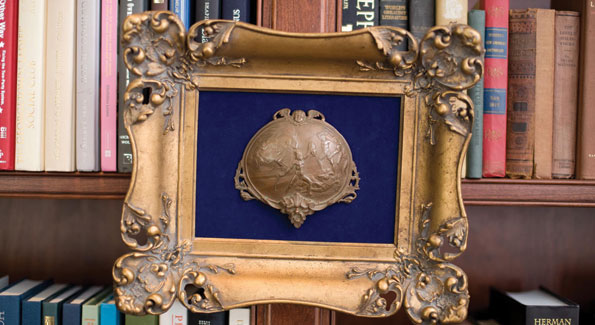 Nothing says study like a well-appointed library and framed artifacts, like this impressive bronze bas-relief hung mid-shelf