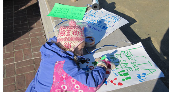 Nell perfects her posters to raise money for Haiti. (Photo by Jane Hess Collins) 