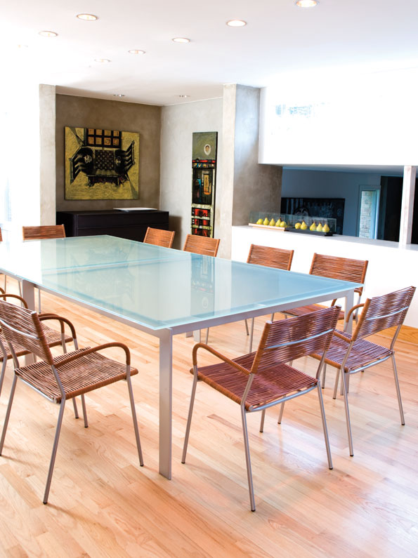 The large glass table in the dining room  serves not only as a contemporary  statement piece, but also provides ample  seating for family and friends. (Photo by John Heale)