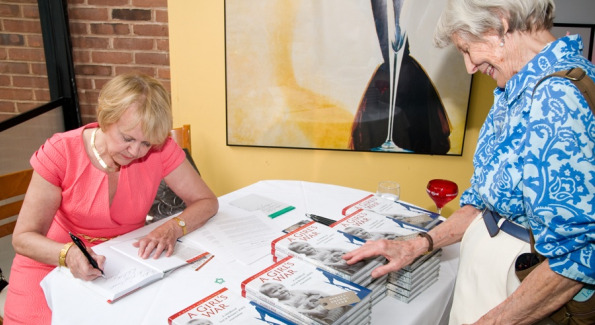 Author Doreen Drewy Lehr signs a copy of her new release and first book, "A Girl's War: A Childhood Lost in Britain's WWII Evacuation" for fellow author Ann McLaughlin, whose sixth novel "Leaving Bayberry House" was just released.