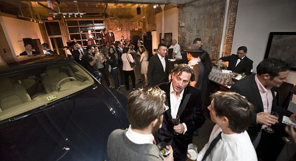 Attendees mingle while admiring the new Porsche Cayenne