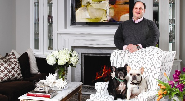 Jeff Akseizer and his French Bulldogs LuLu and Louie love to entertain in the living room of his renovated McLean, Va. home. He paired a hickory chair wingback with a Bolier & Co. sofa in rich warm colors and added a David Hicks patterned Stark rug, antique coffee table with 14-kt. gold trim and Carrera marble top, and rare coral for color and contrast. The built-ins around the fireplace, which is his favorite “accessory” in the house, are from his own ADG Millwork Shop in Boswell, Penn. Additional decor by Jamie Brown of Akseizer Design Group. 