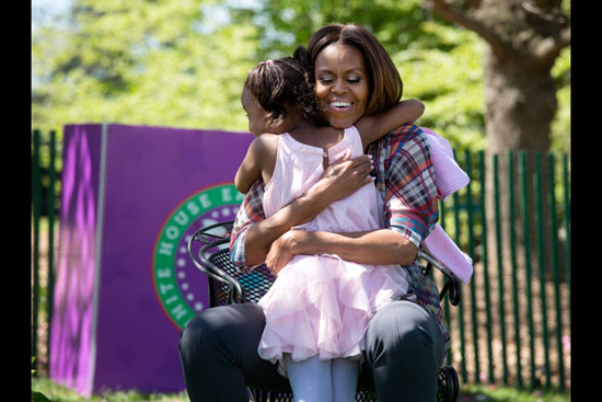 First lady Michelle Obama hugs a child (Photo by Chuck Kennedy)