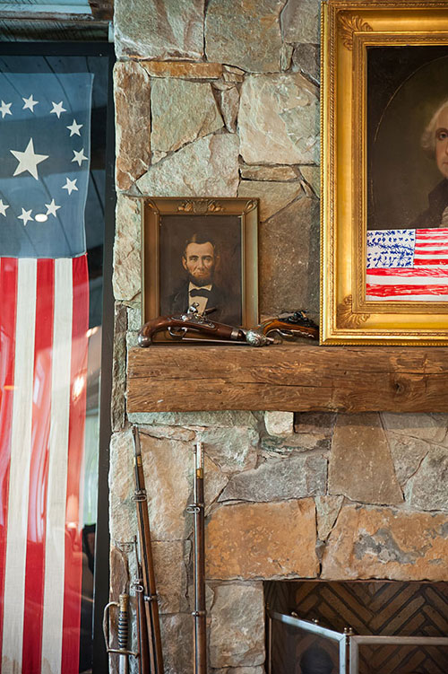 Detail of an Abraham Lincoln oil and antique rifles.