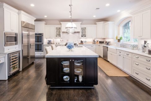 The spacious kitchen features marble counters, double ovens, two dishwashers, pendant lights from Restoration Hardware and white Dura Supreme cabinetry.